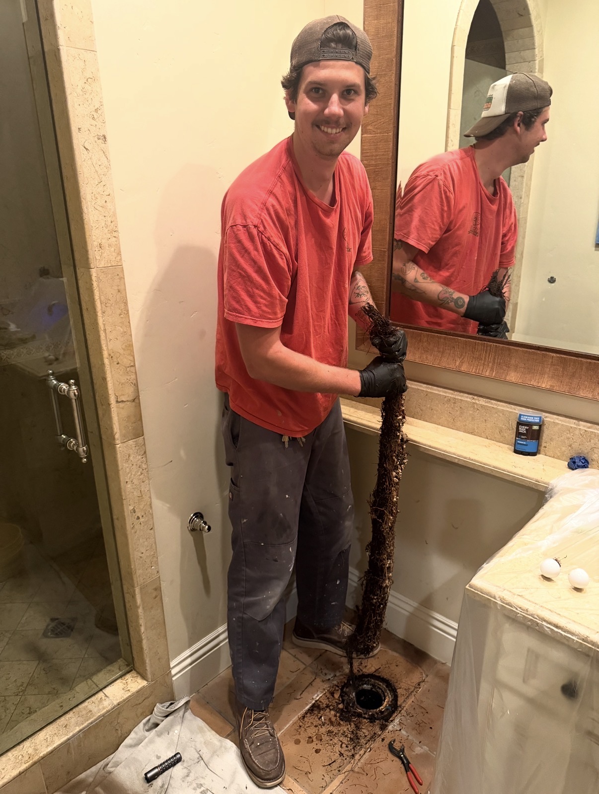 Crew member clearing a bathroom drain
