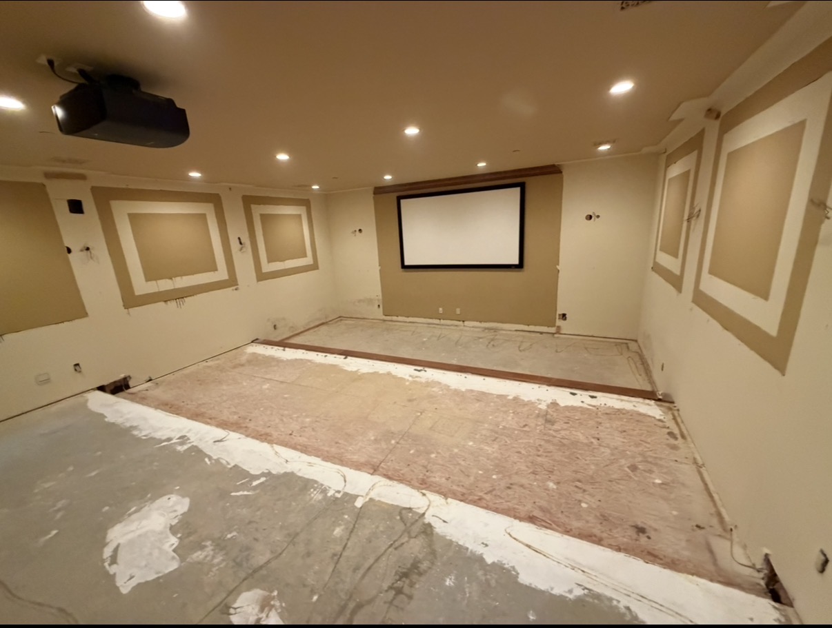 Home theater during renovation, with flooring removed and walls awaiting finish work